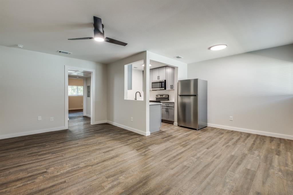 a view of kitchen with stainless steel appliances a refrigerator and wooden floor