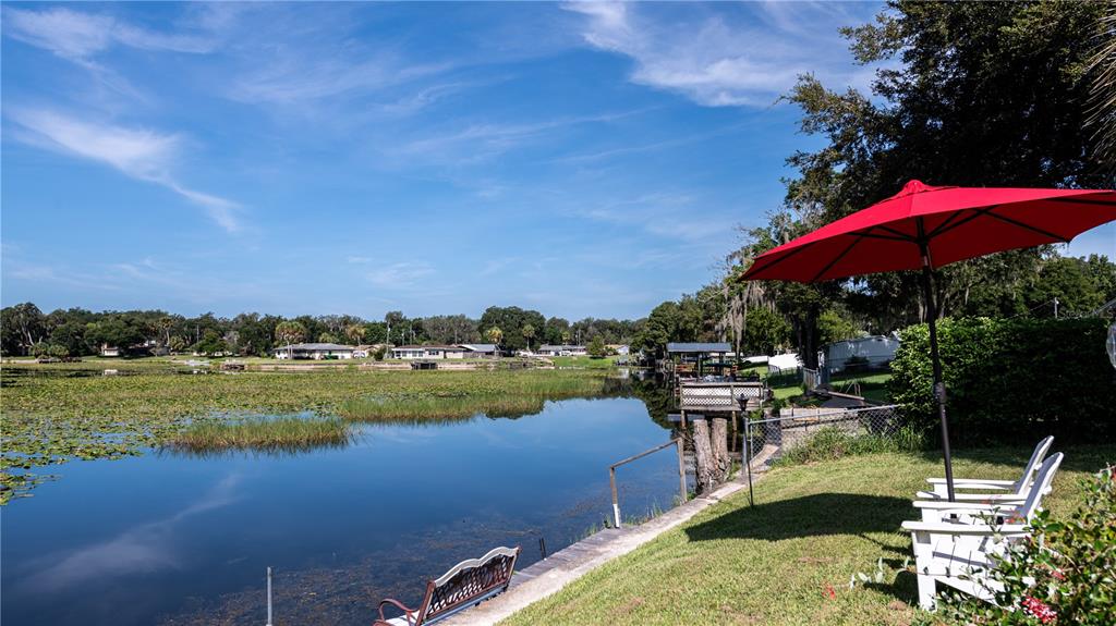 a view of a lake with a table chairs and a fire pit