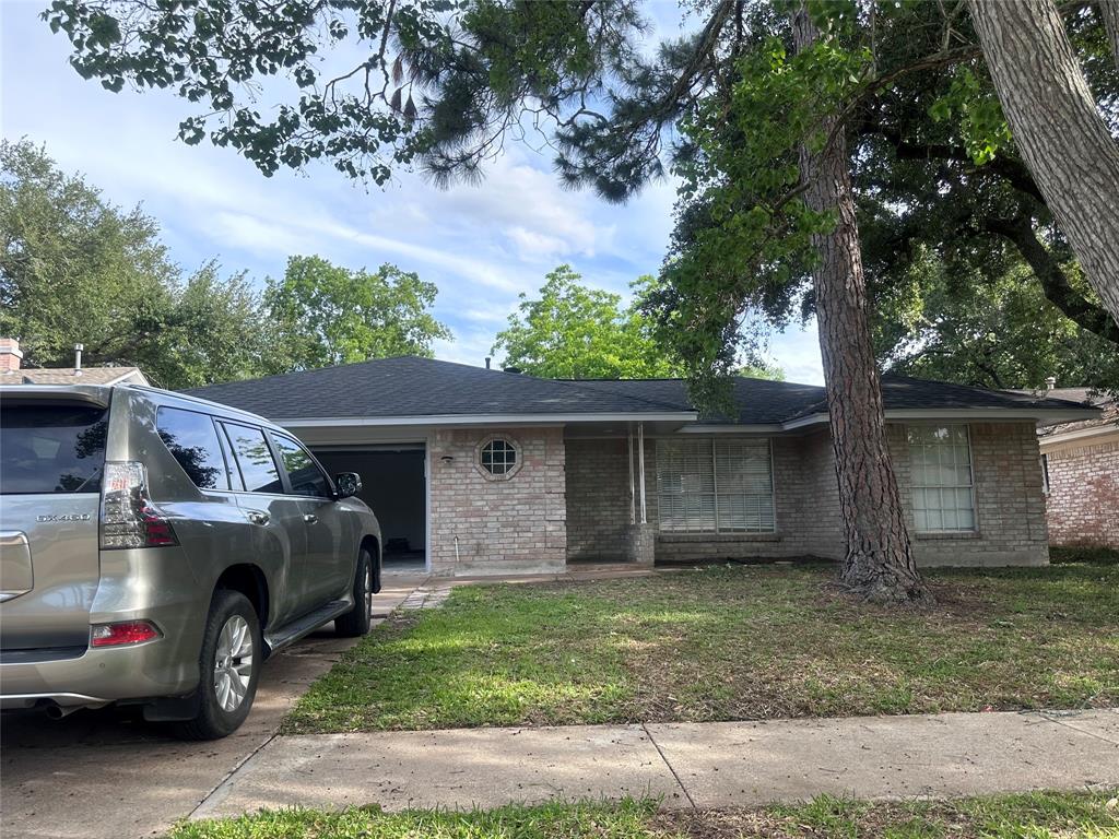 a view of house with car parked beside of it