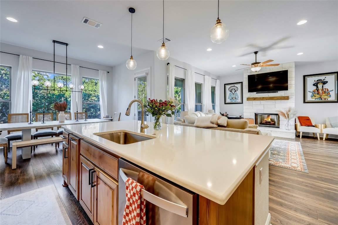 a kitchen with stainless steel appliances granite countertop a sink a stove and a wooden floors