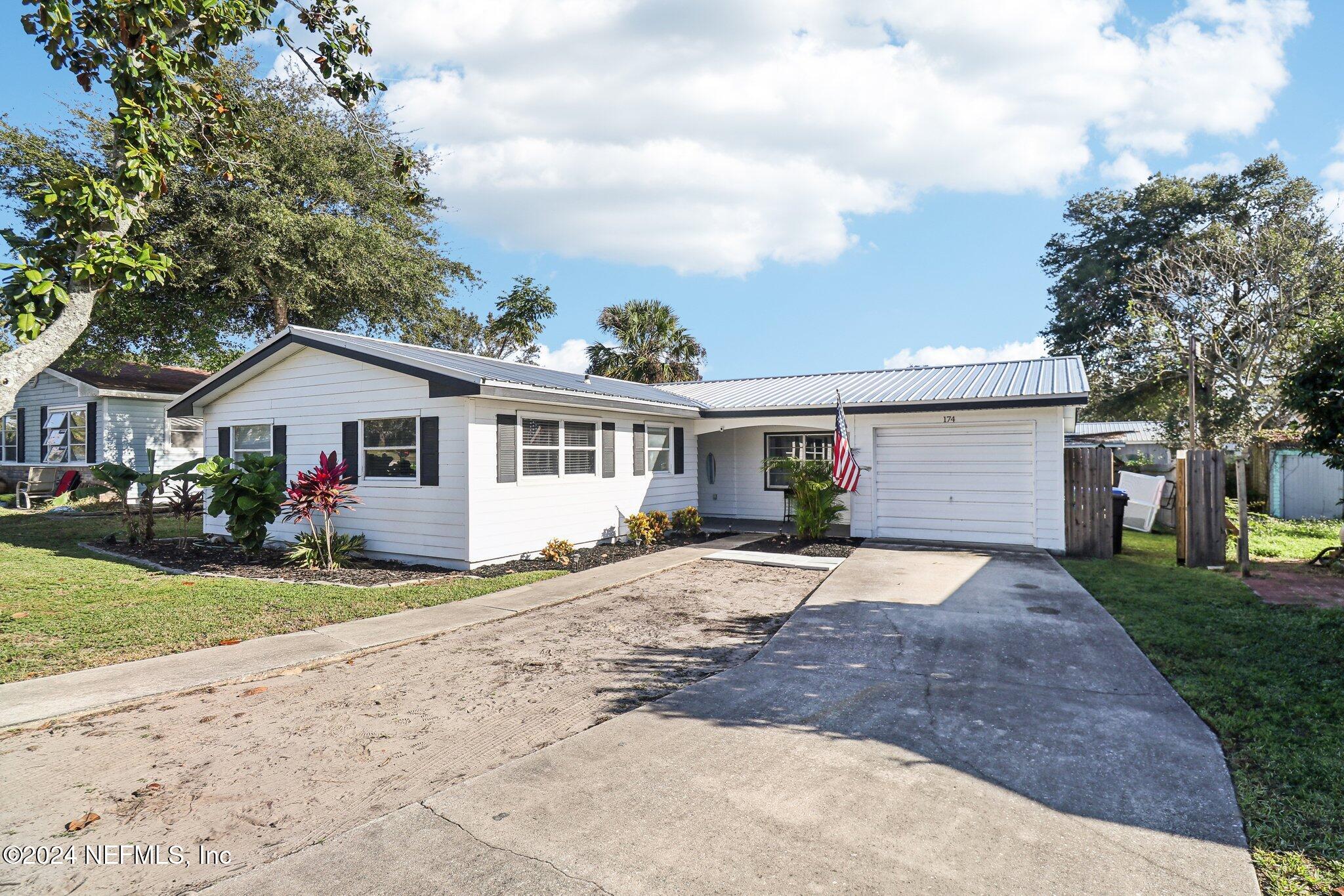 a front view of house with yard and trees around