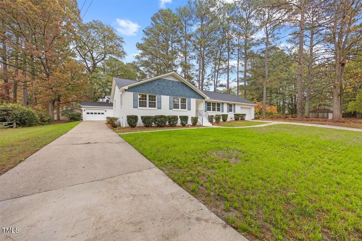 a front view of a house with a yard and trees