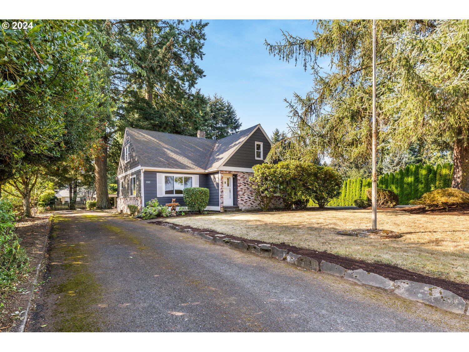 a front view of a house with a yard and trees