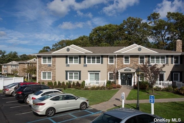 a front view of a house with a garden and trees