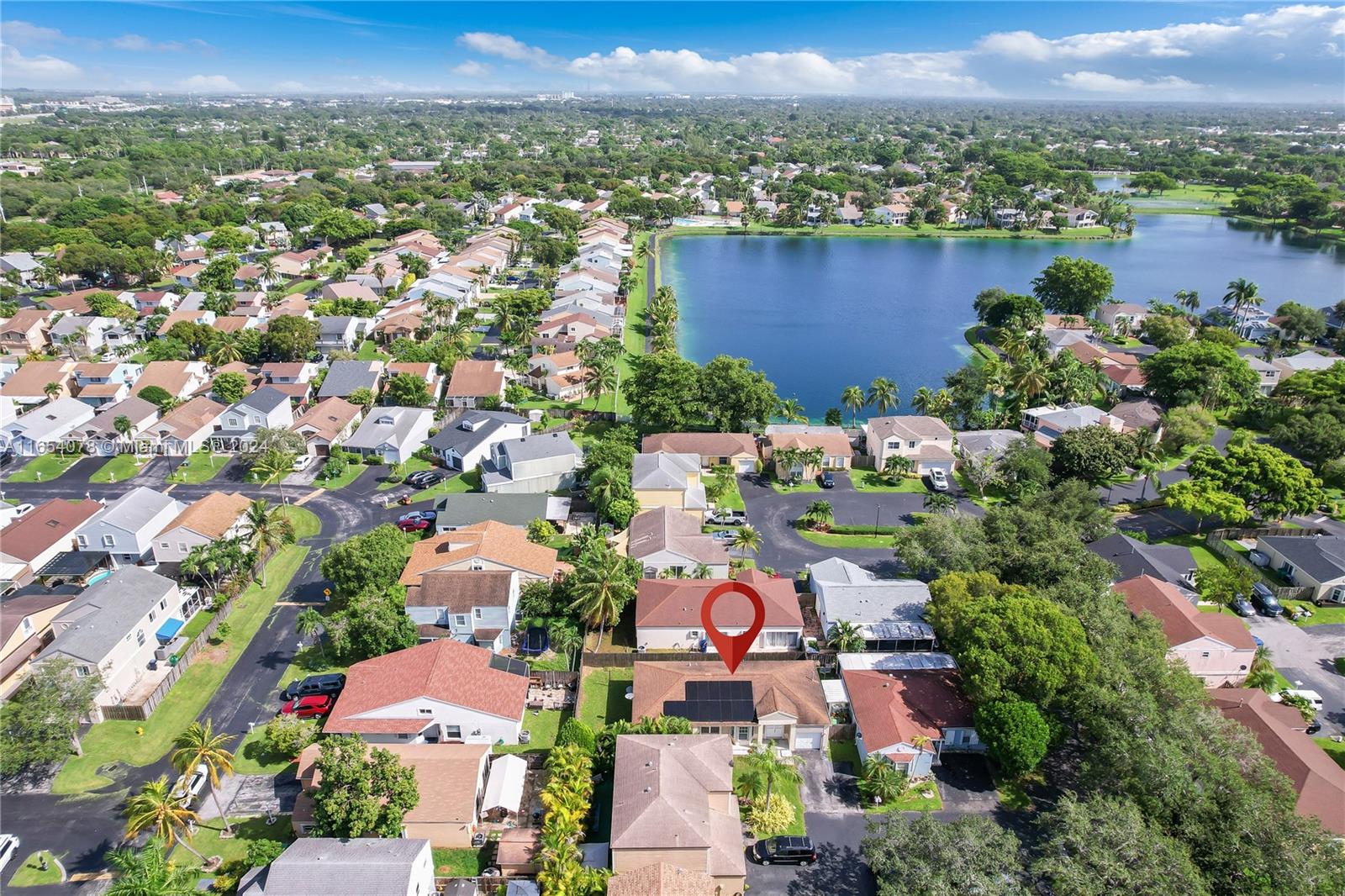 an aerial view of a city with lots of residential buildings ocean and mountain view in back