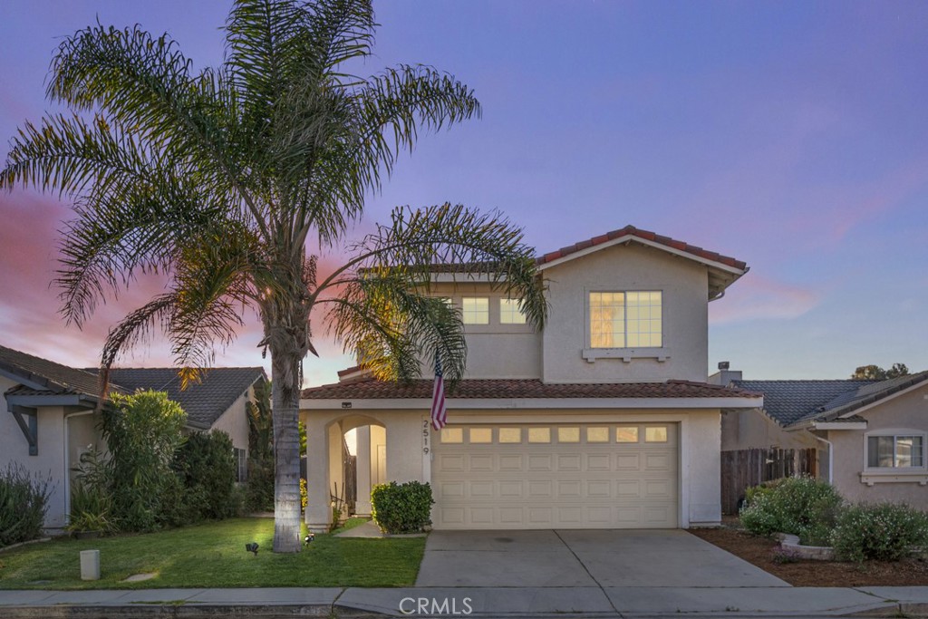 a front view of a house with a yard and garage