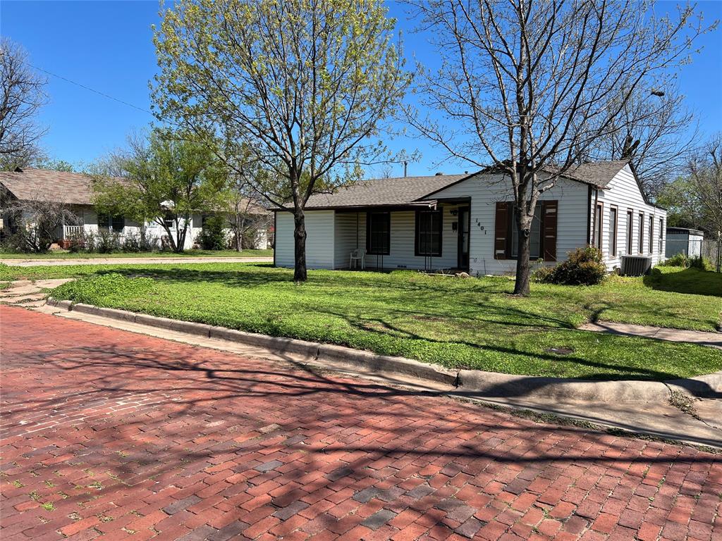 a front view of a house with a yard and trees