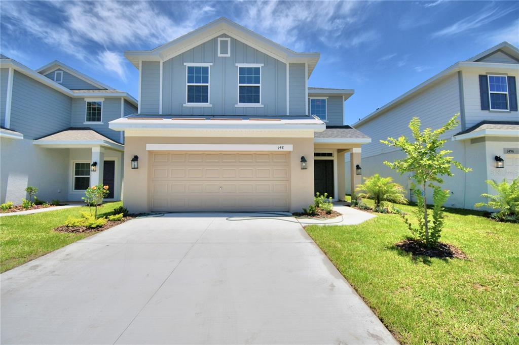 a front view of a house with a yard and garage