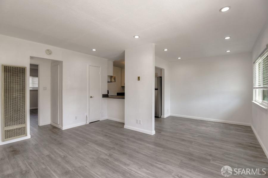 a view of empty room with wooden floor