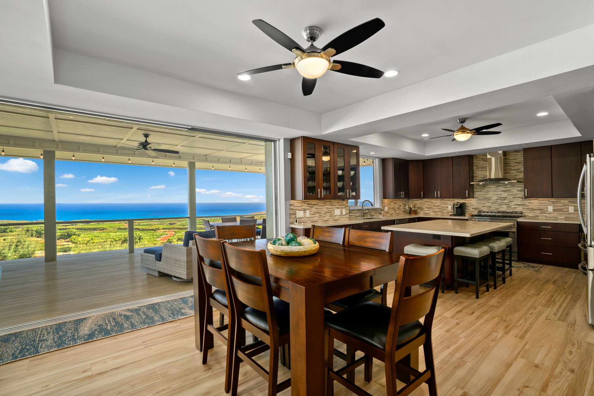 a dining room with stainless steel appliances kitchen island granite countertop a table chairs and a chandelier