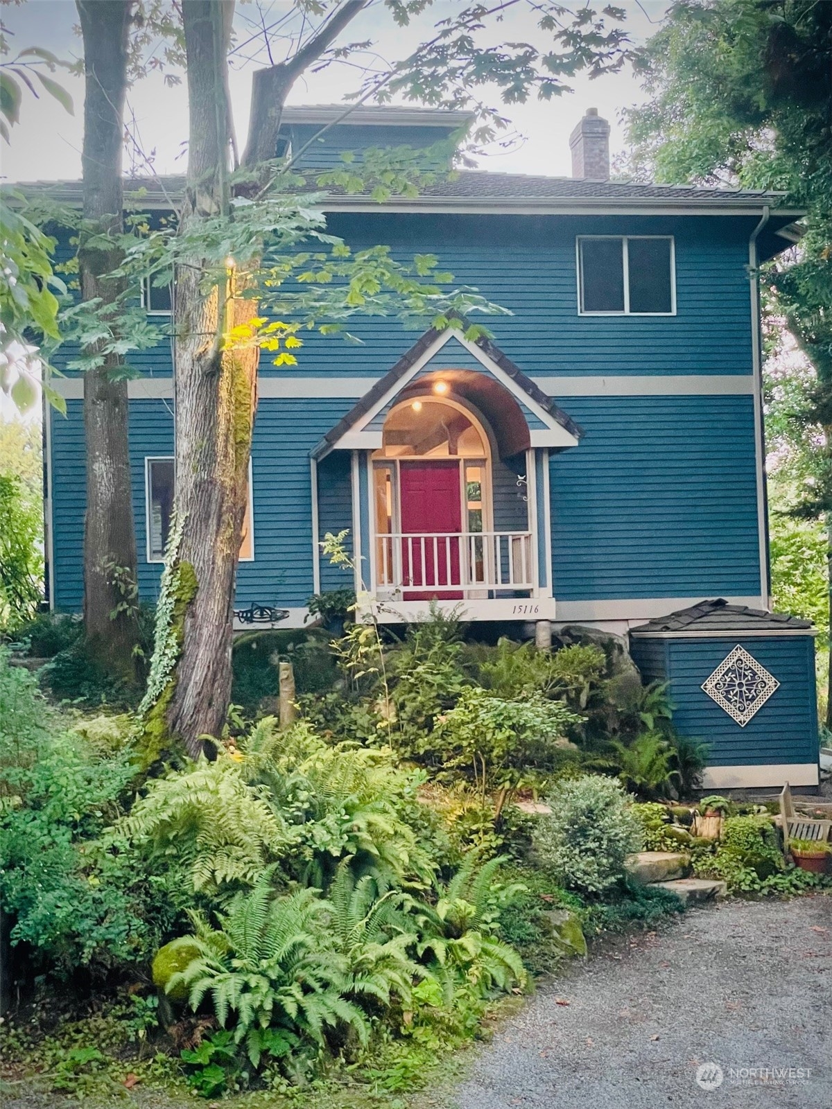 a front view of a house with a yard and potted plants