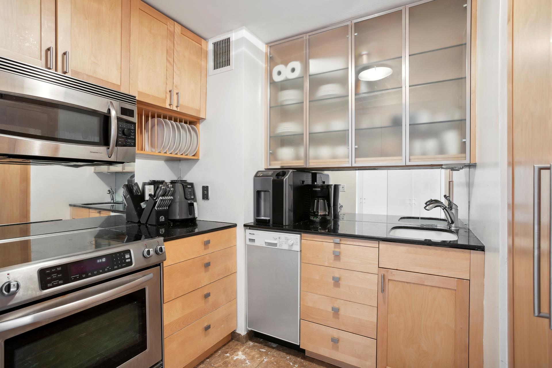 a kitchen with granite countertop white cabinets and appliances