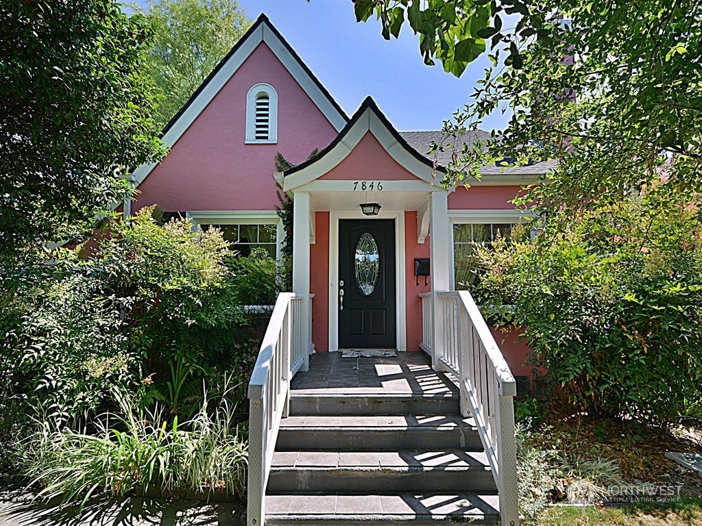 a front view of a house with entryway and plants