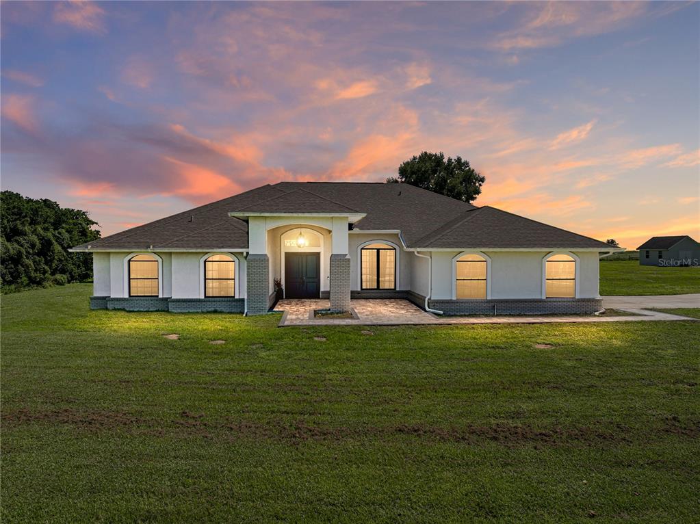 a front view of a house with yard and green space