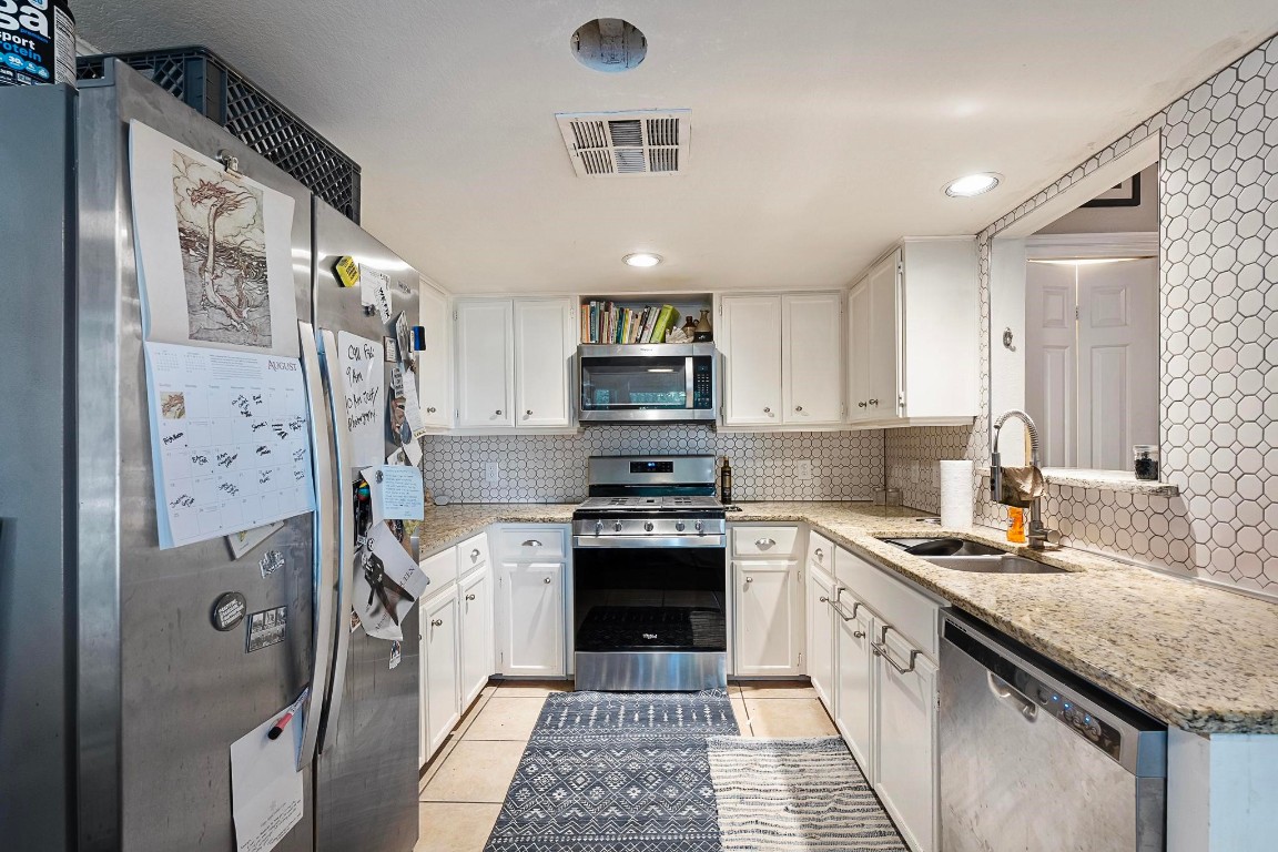 a kitchen with stainless steel appliances granite countertop a stove sink and refrigerator