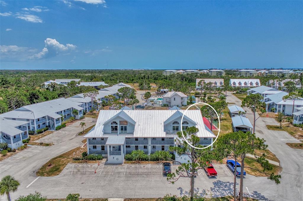 an aerial view of residential houses with outdoor space and ocean view