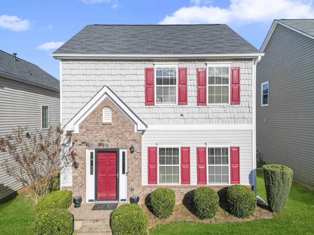 a front view of brick house with a yard