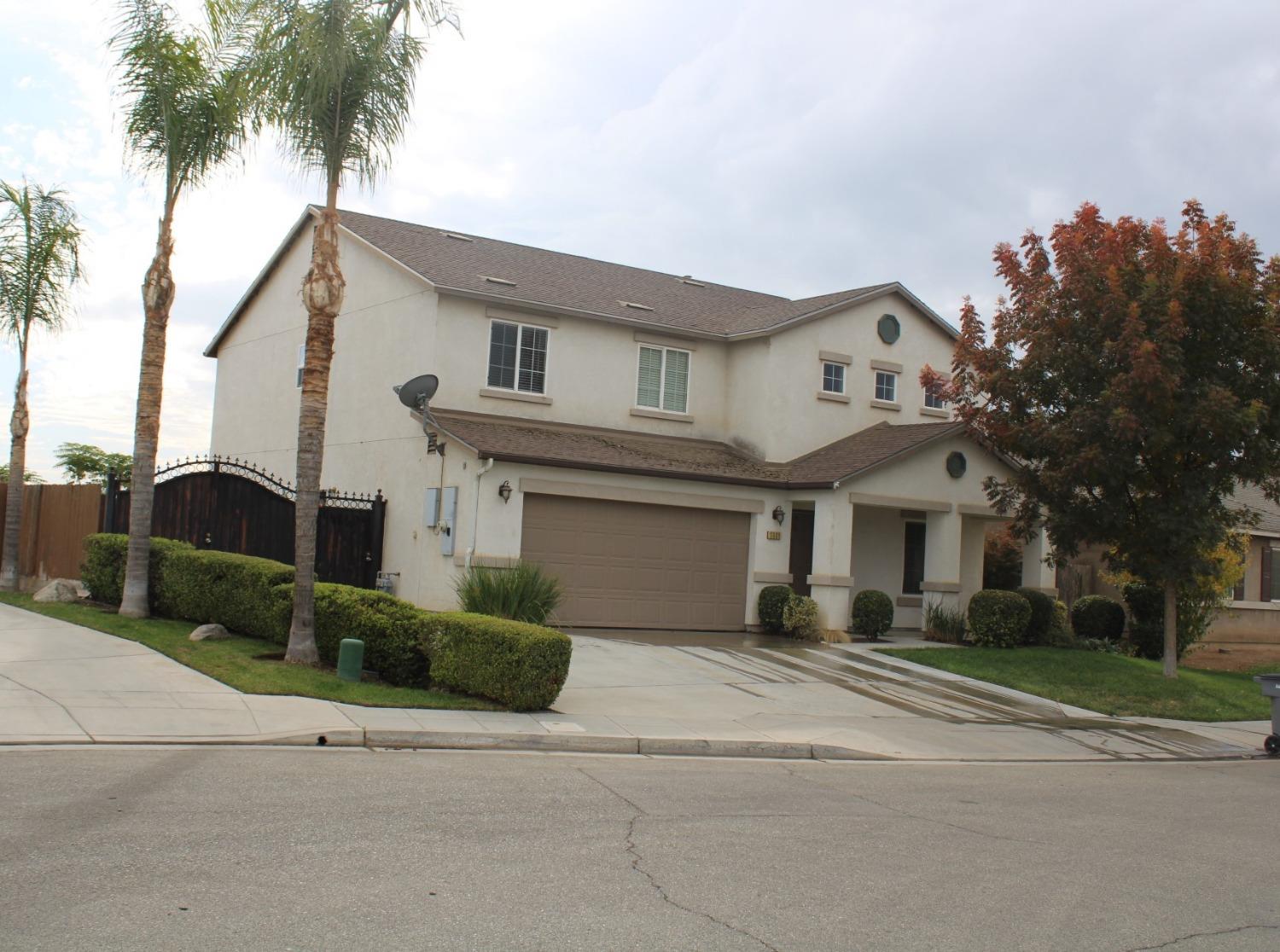 a front view of a house with a garden and trees