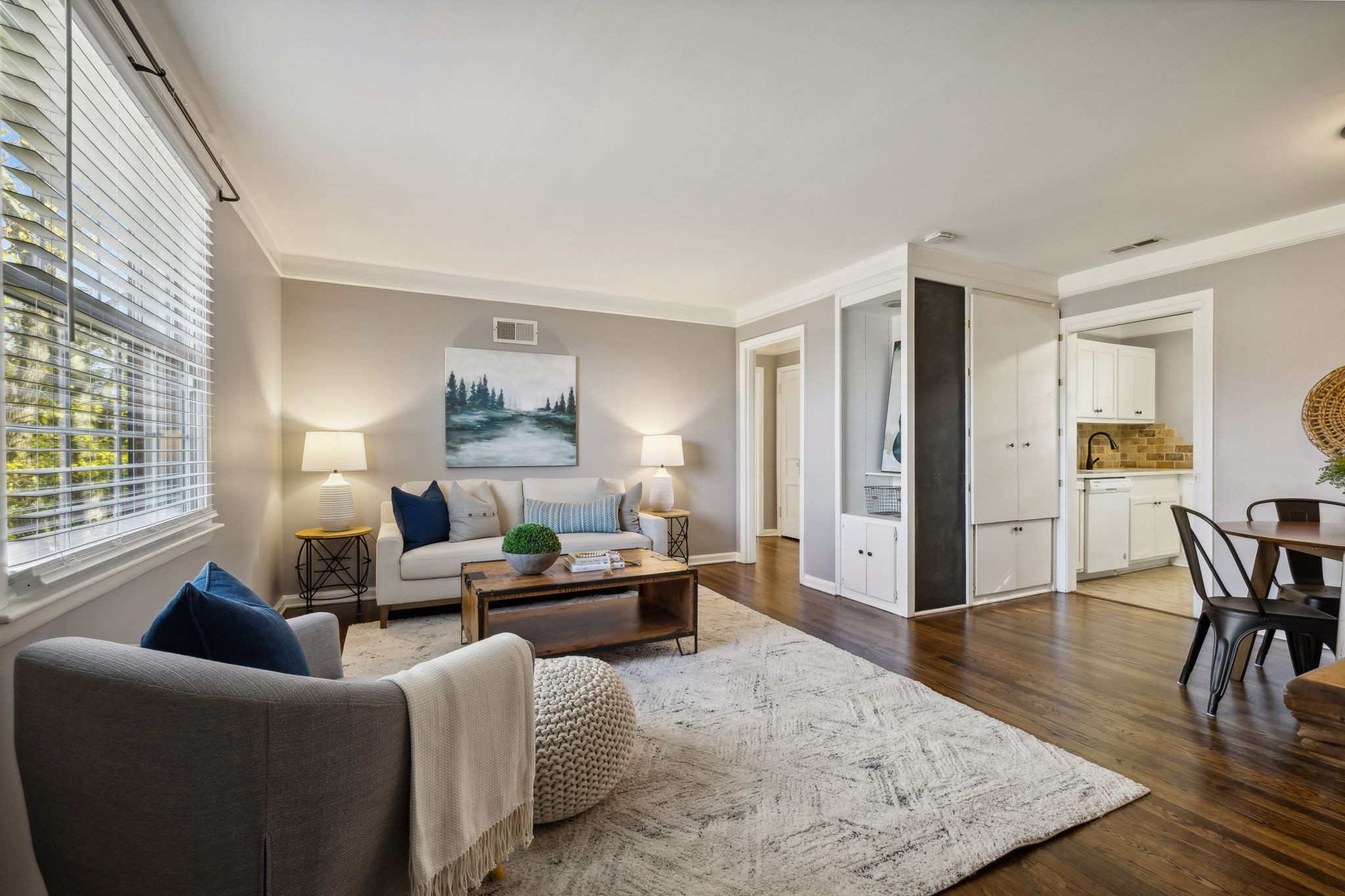 a living room with furniture wooden floor and a lamp