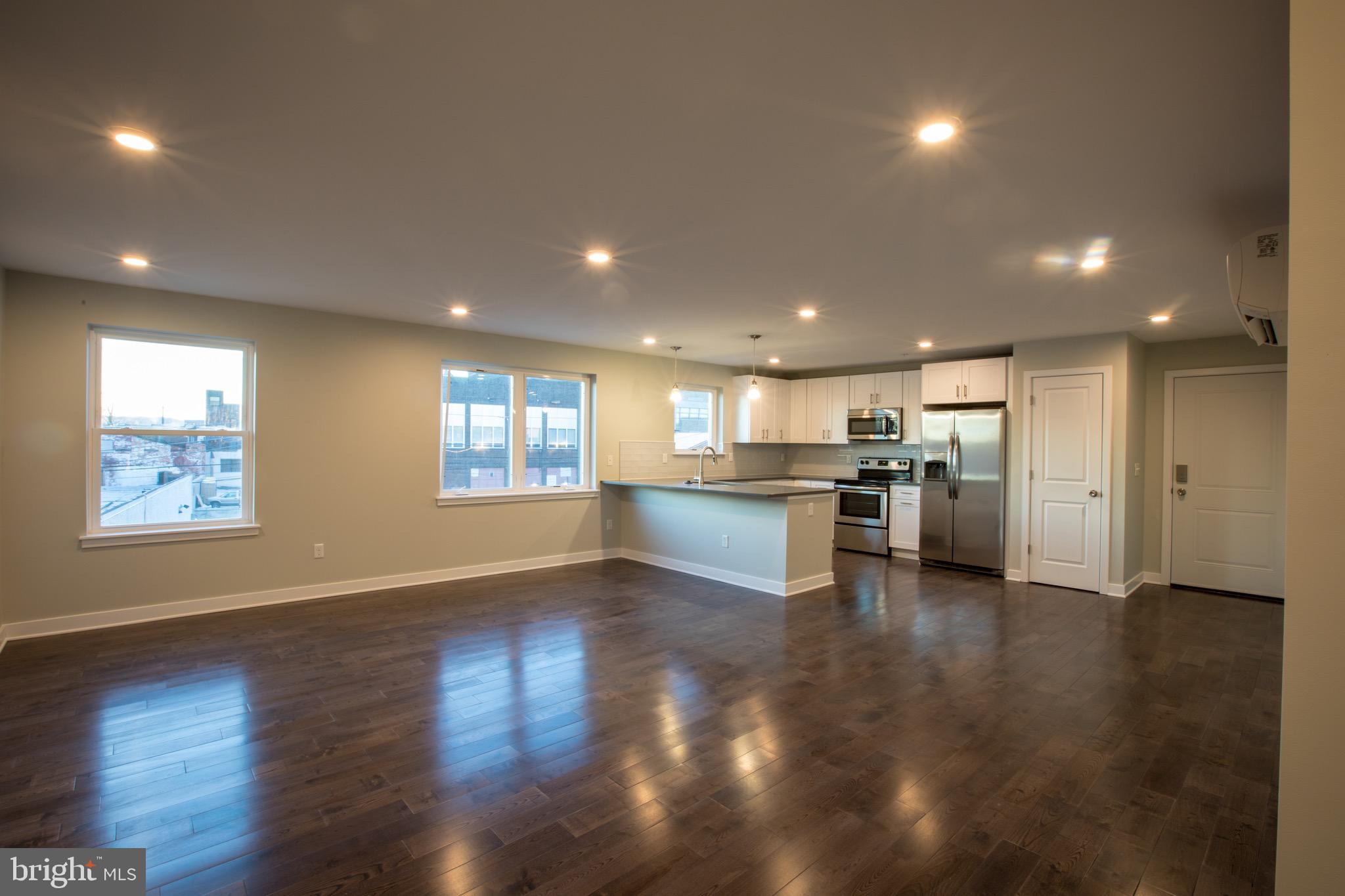 an empty room with wooden floor and kitchen kitchen