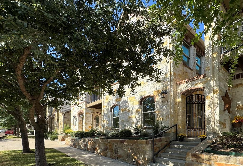 a front view of a house with a tree