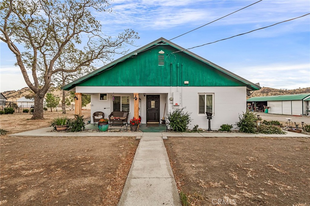 a front view of a house with a yard and potted plants