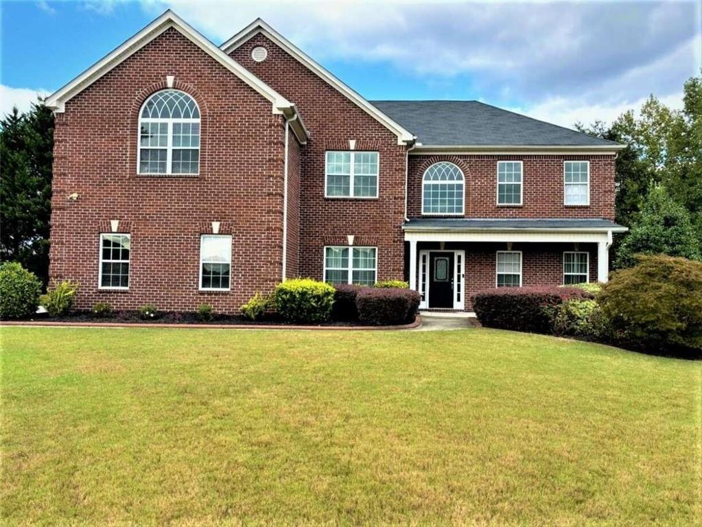 a front view of a house with yard and garage