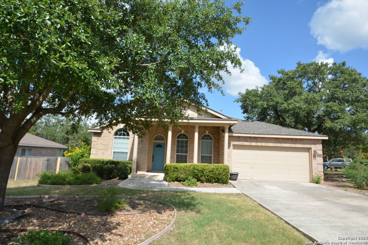 a front view of a house with a yard and trees