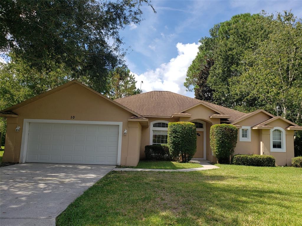 a front view of a house with a garden and yard