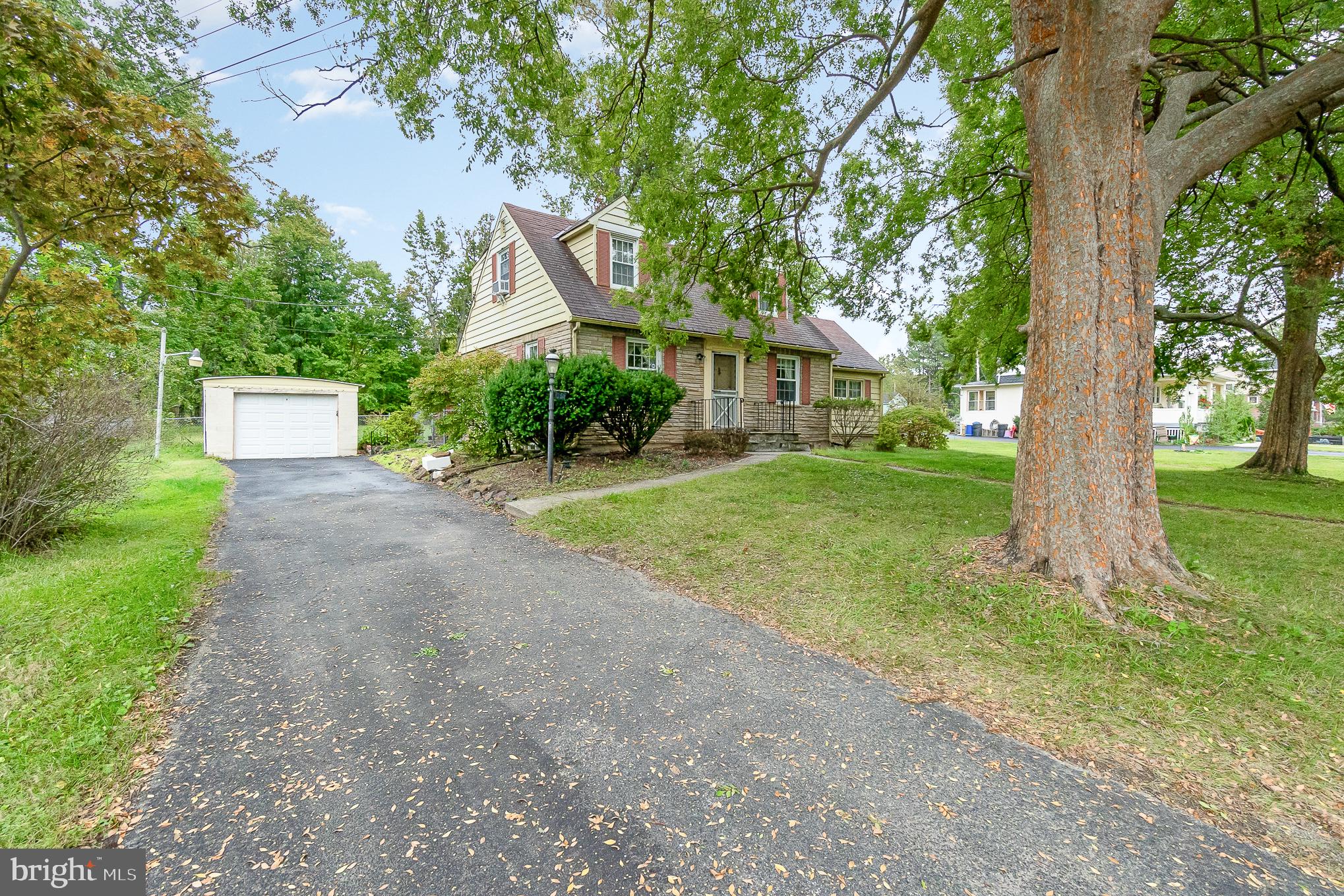 a front view of a house with a yard and large trees