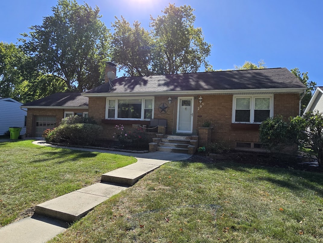 a view of a house with a yard and potted plants