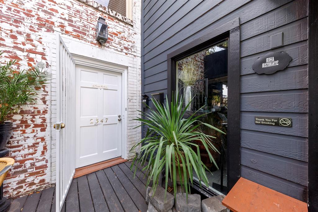 a view of a house with a potted plant and floor to ceiling window