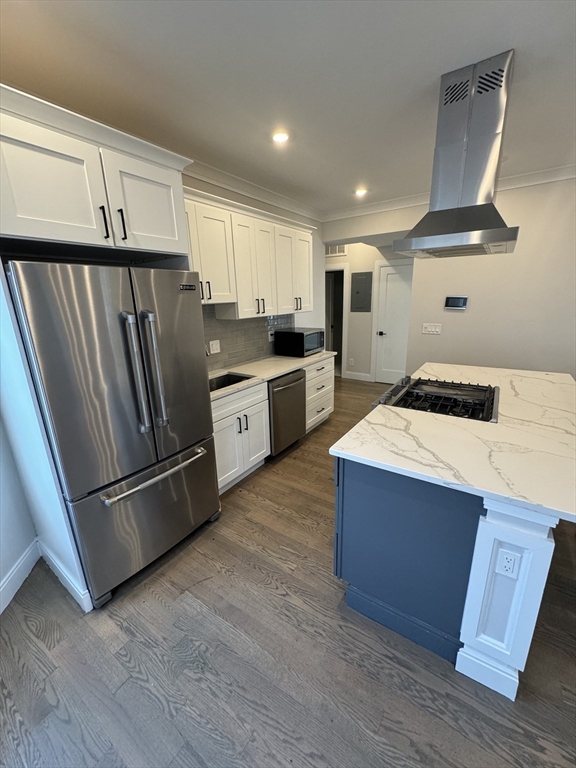 a kitchen with stainless steel appliances a refrigerator and wooden floor