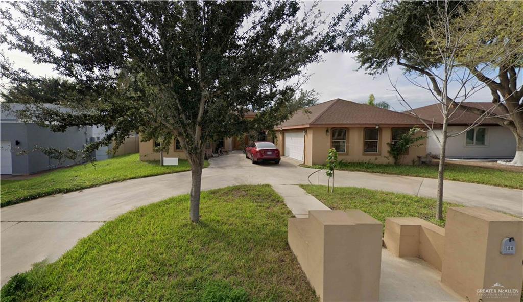 View of front of house featuring a front yard and a garage