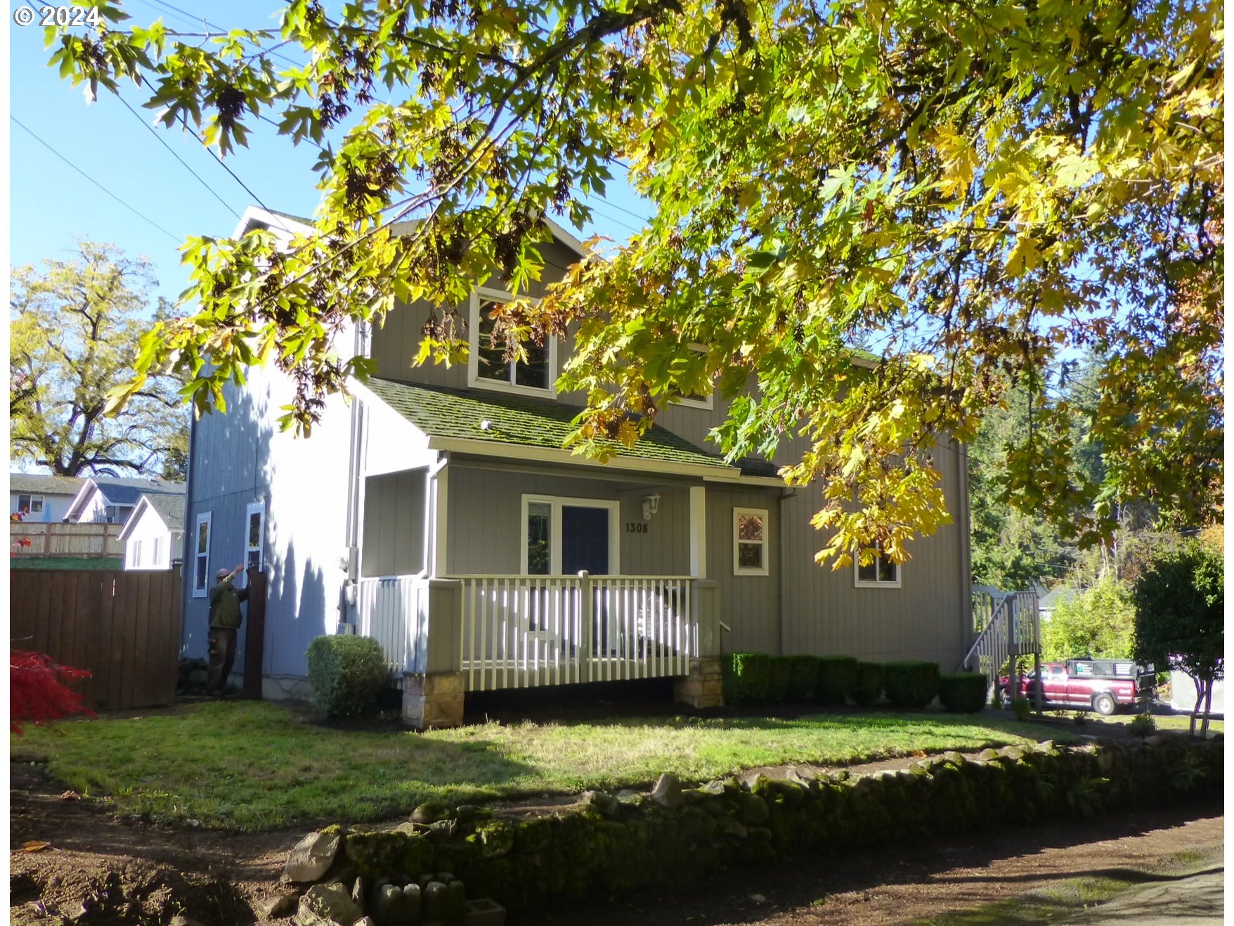 a front view of a house with a garden and trees