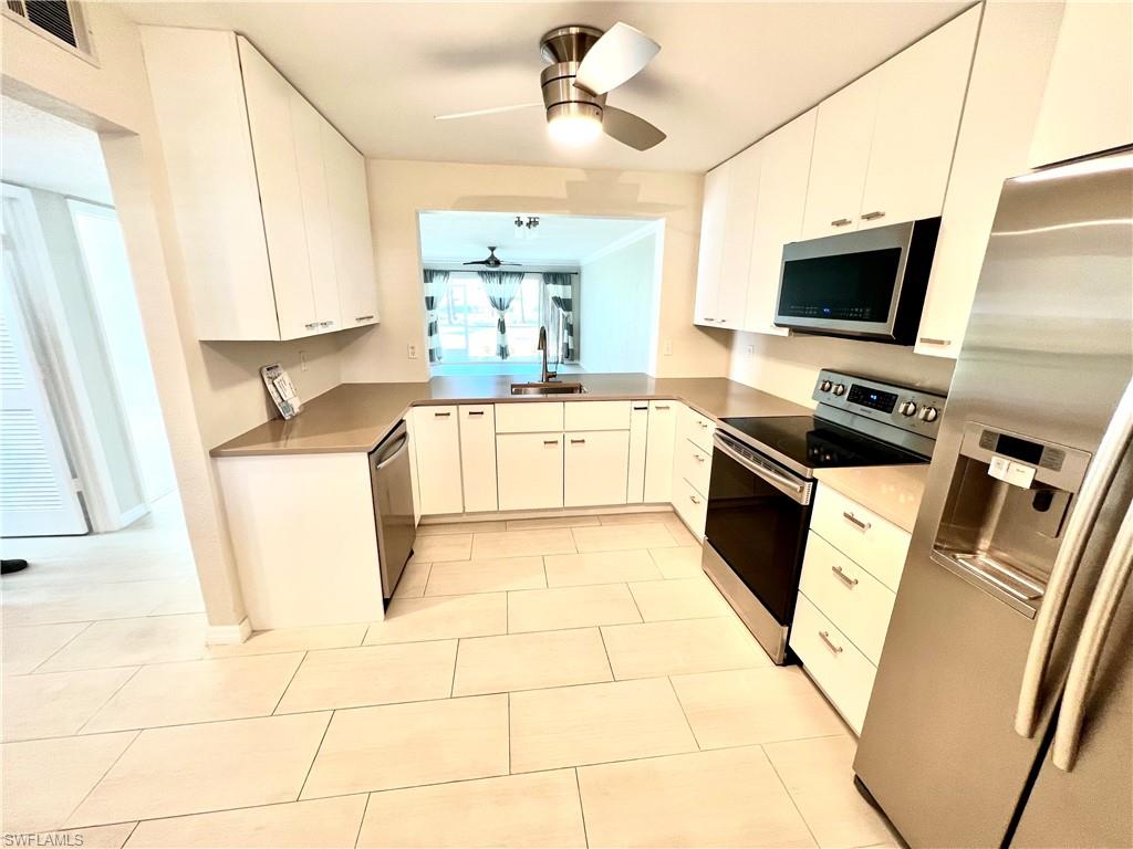 a kitchen with stainless steel appliances a stove a sink and a refrigerator