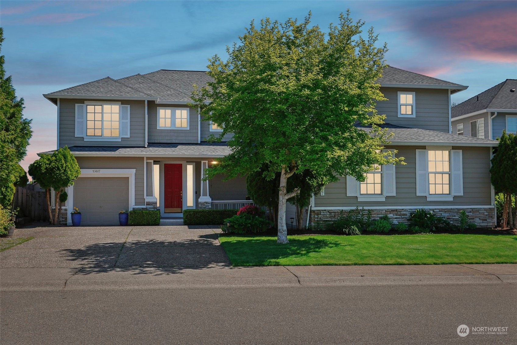 a front view of a house with a yard and a garage