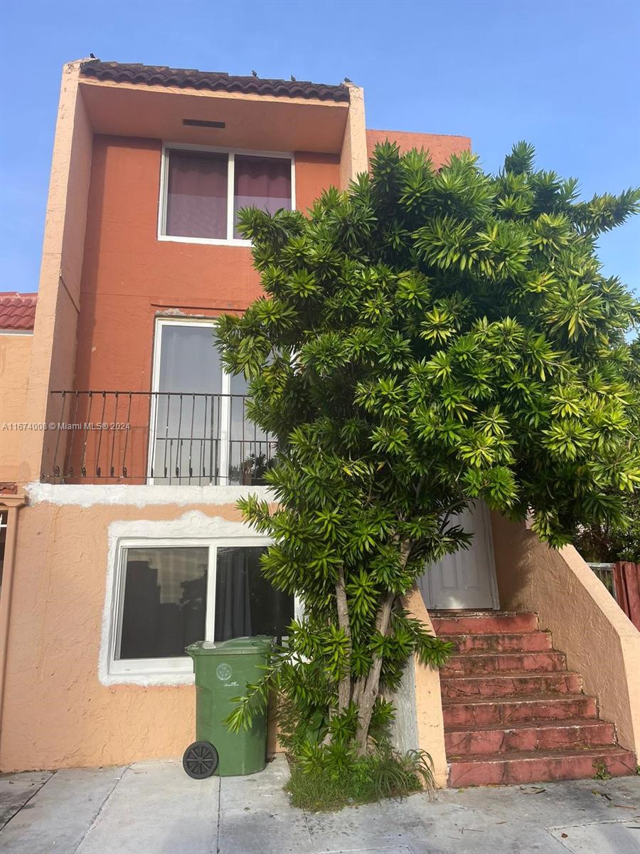 a front view of a house with plants