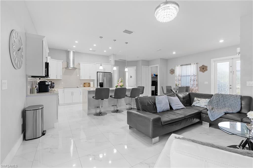 a living room with furniture kitchen view and a refrigerator