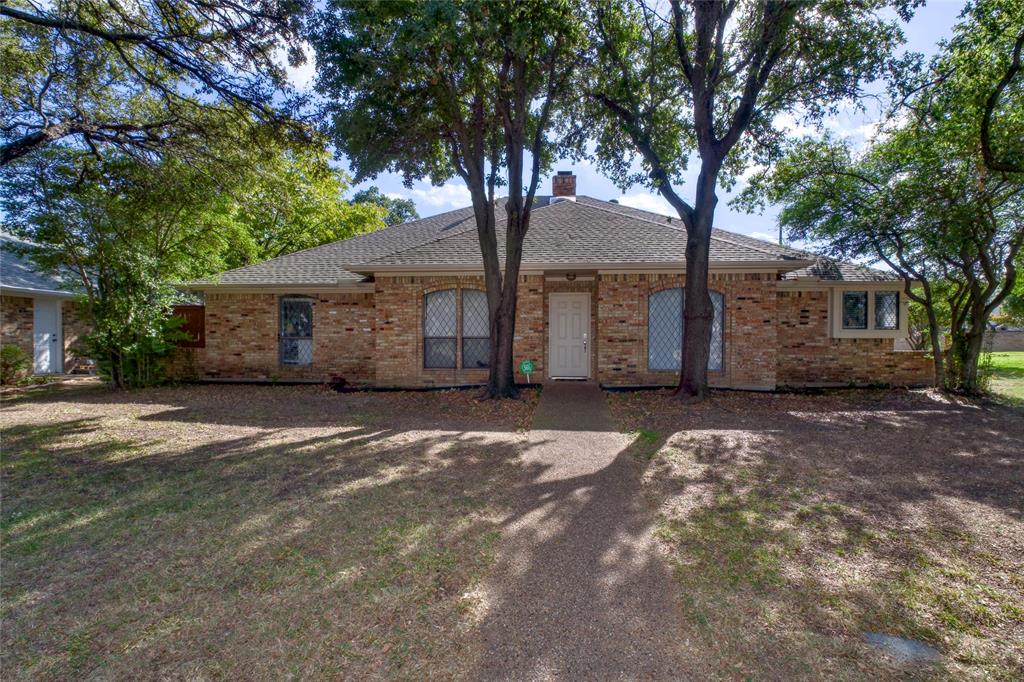 a view of a house with a tree in front of it