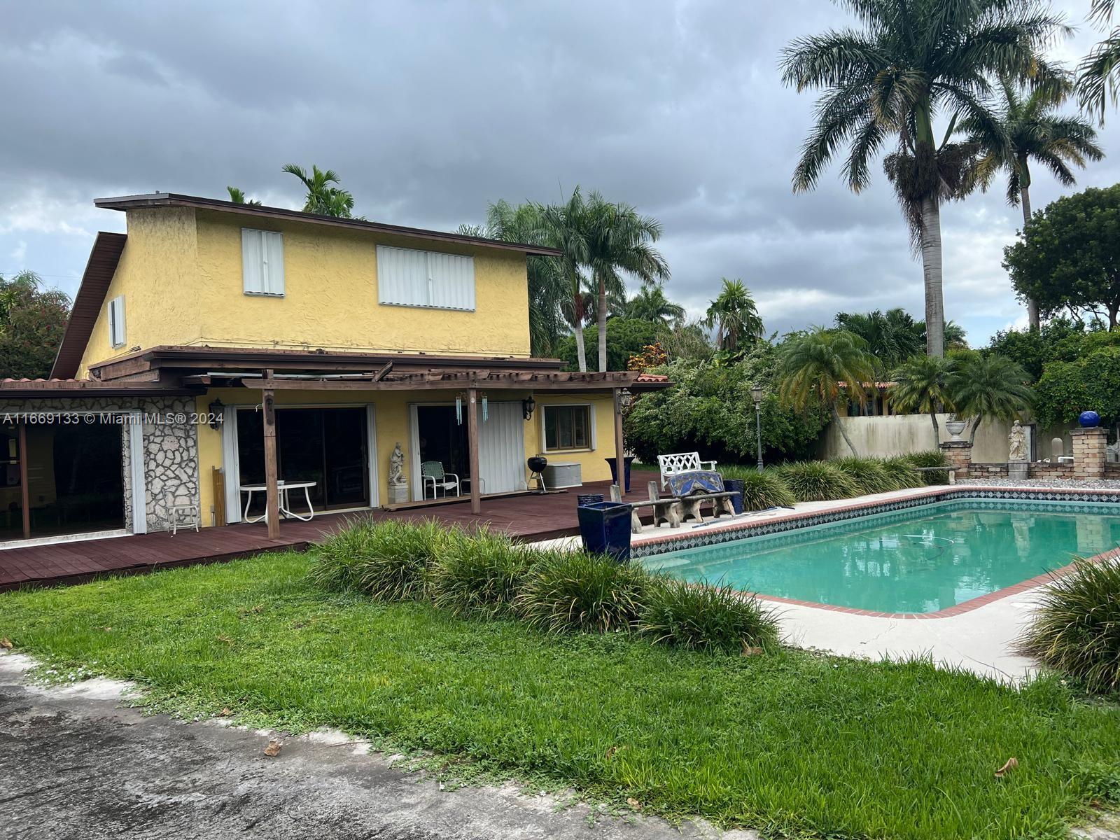 a view of a house with swimming pool and a chairs