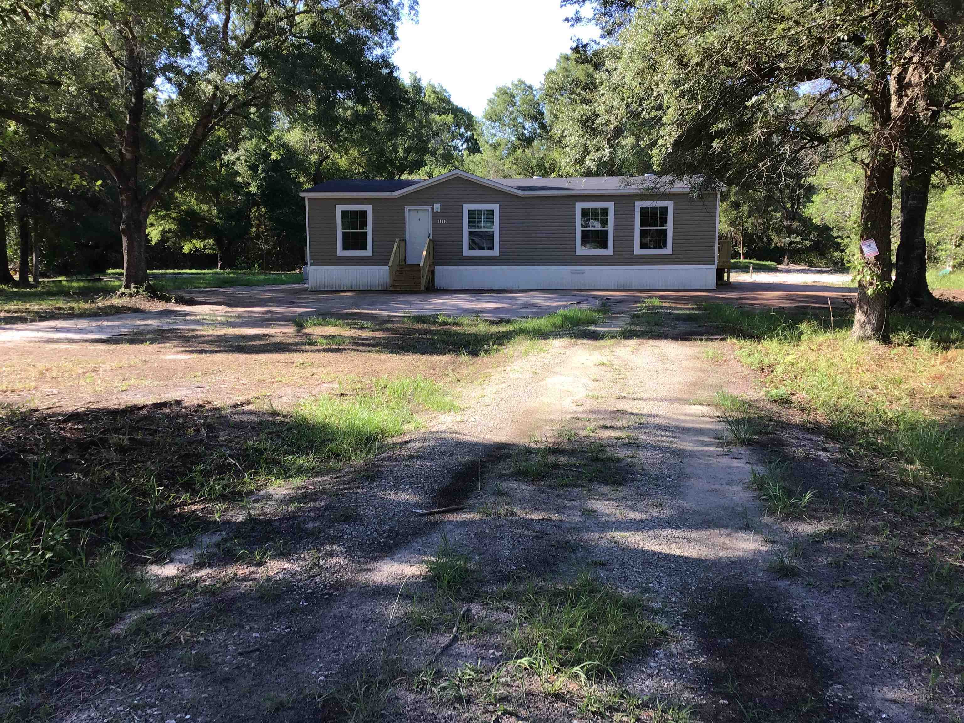 a front view of a house with a yard and trees