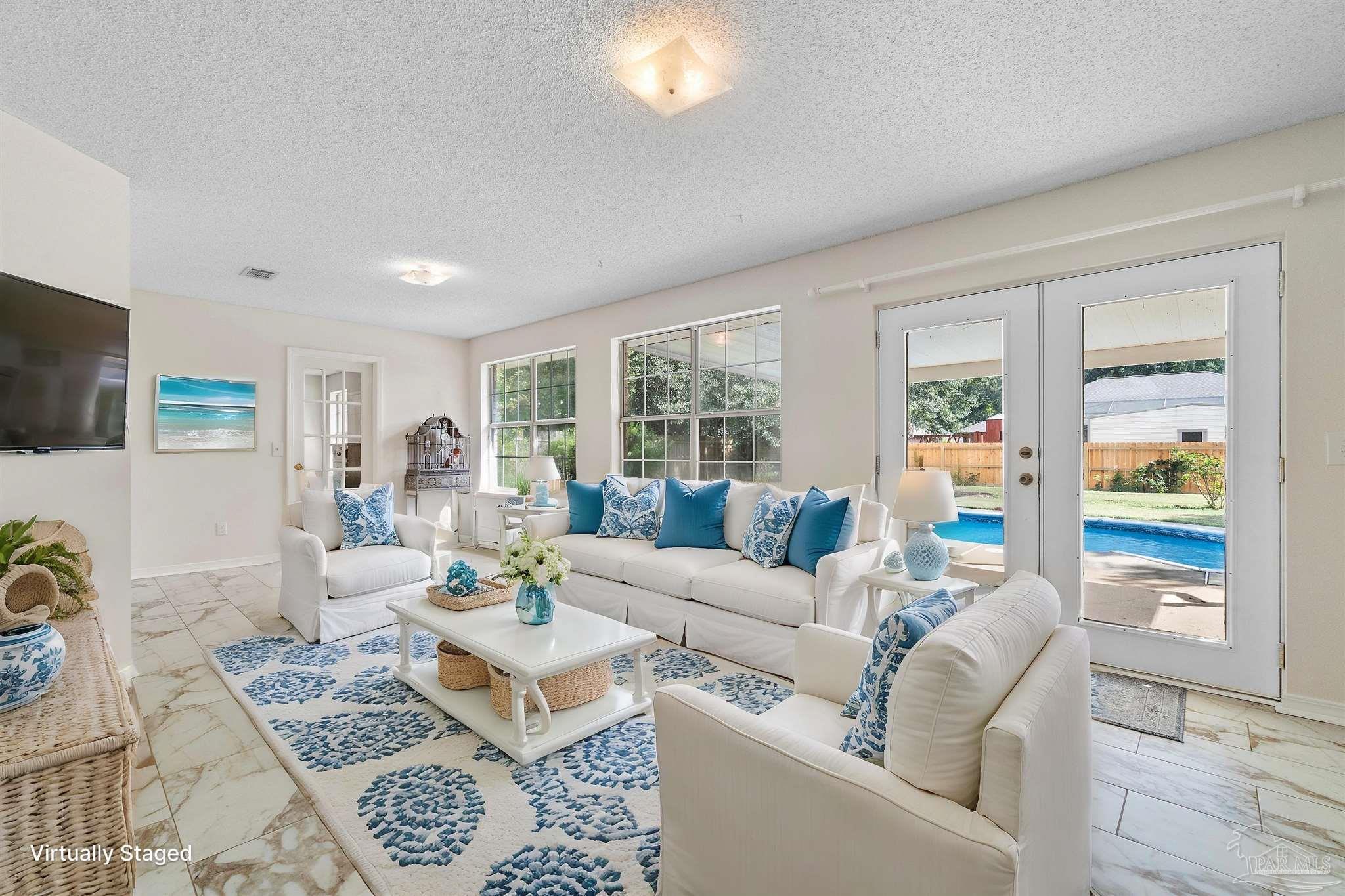 a living room with furniture a flat screen tv and a window