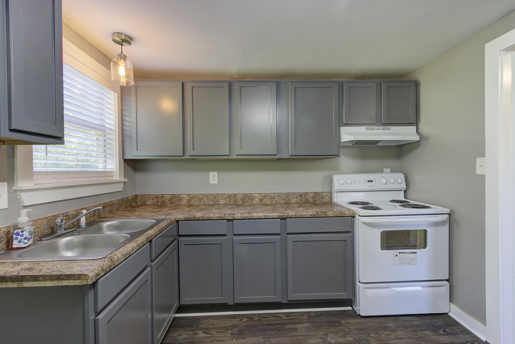 a kitchen with a sink stove and cabinets