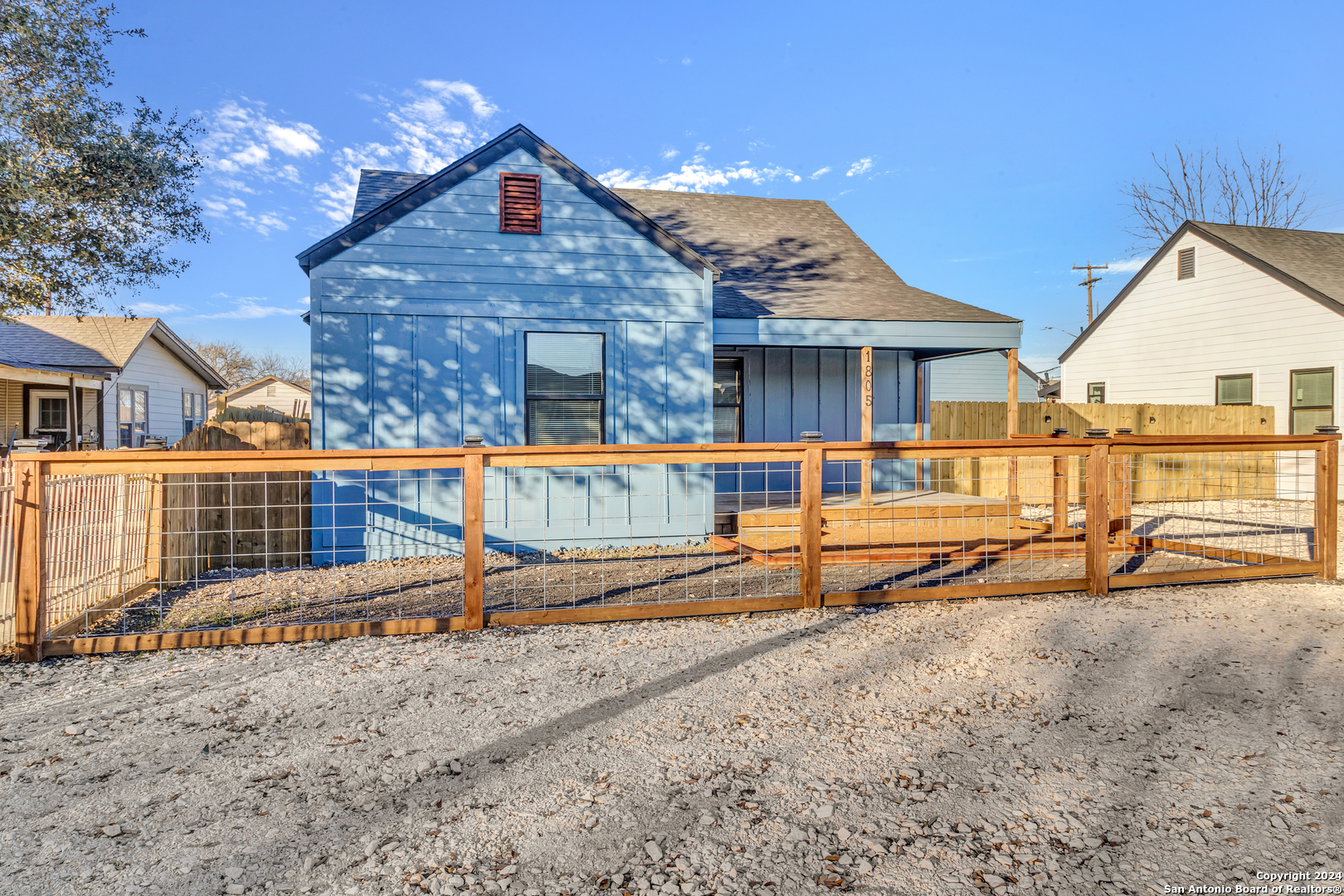 a view of a house with wooden fence