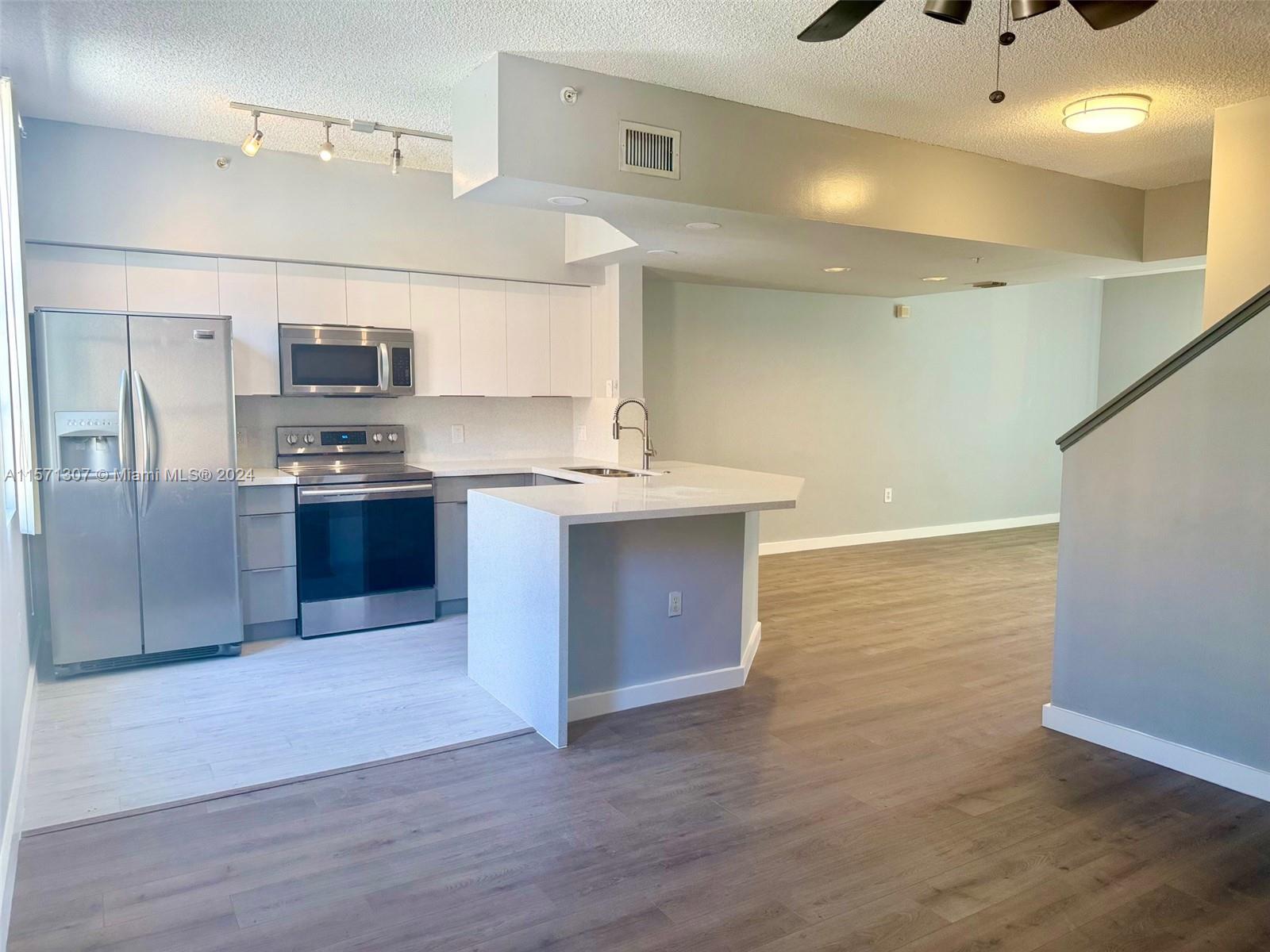 a kitchen with stainless steel appliances granite countertop a sink and cabinets