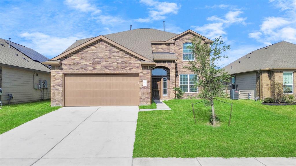 a front view of a house with a yard and garage