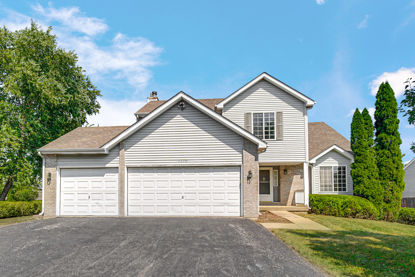 a front view of a house with a yard and garage