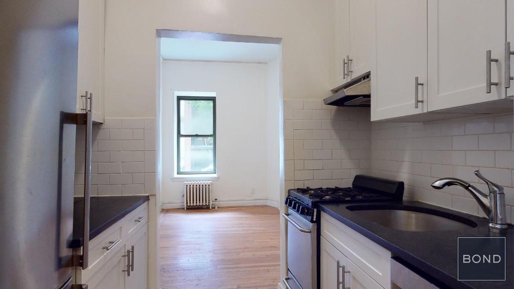 a kitchen with granite countertop a sink stove and cabinets