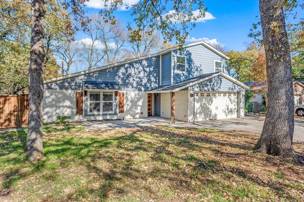 View of property featuring a garage and a front yard